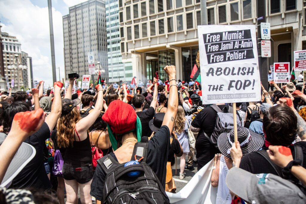 mumiaabujamalprotest Protesters raised fists for nine minutes in front of Philadelphia’s Municipal Service Building on the Fourth of July. (Kimberly Paynter/WHYY)