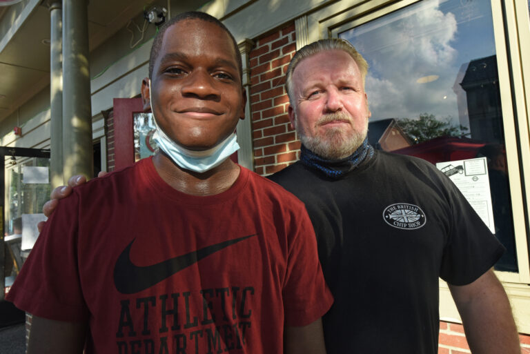After discovering that the charges against him had been dropped, Timothy Cook shares a moment with The British Chip Shop owner Ian Whitfield in Haddonfield where he has been working parttime as a dishwasher for a year. (April Saul for WHYY)