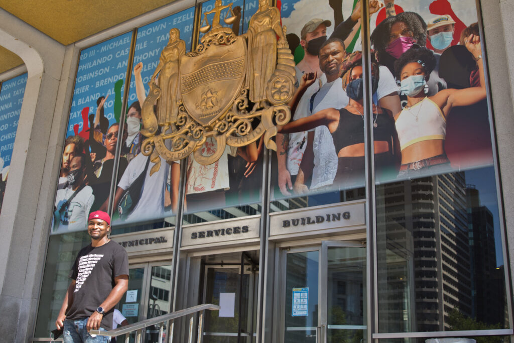 2020 8 26 k paynter blm mural-5 Mural artist Russell Craig included his own image in the crown-shaped collage of protesters now on Philadelphia’s Municipal Services building, behind where the statue of controversial Mayor Frank Rizzo stood until June. (Kimberly Paynter/WHYY)