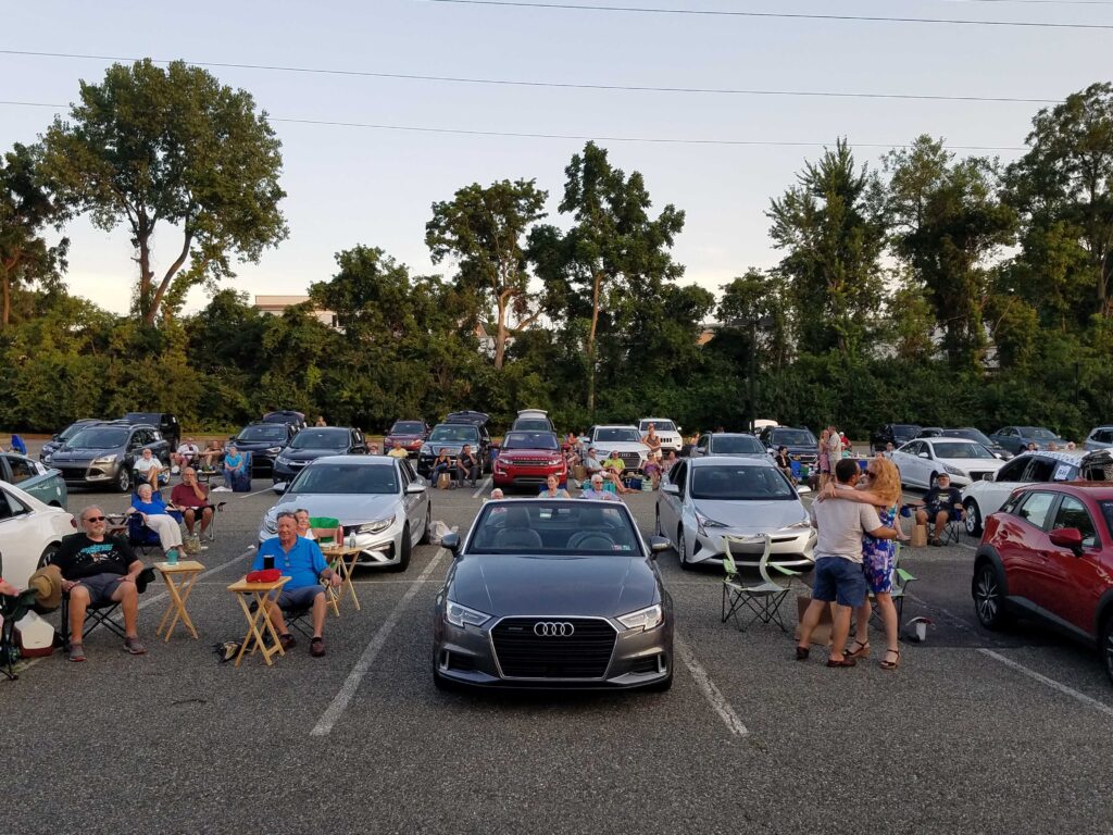 20200725_194726 People and cars gathered at a parking lot turned into a drive-in during the coronavirus pandemic