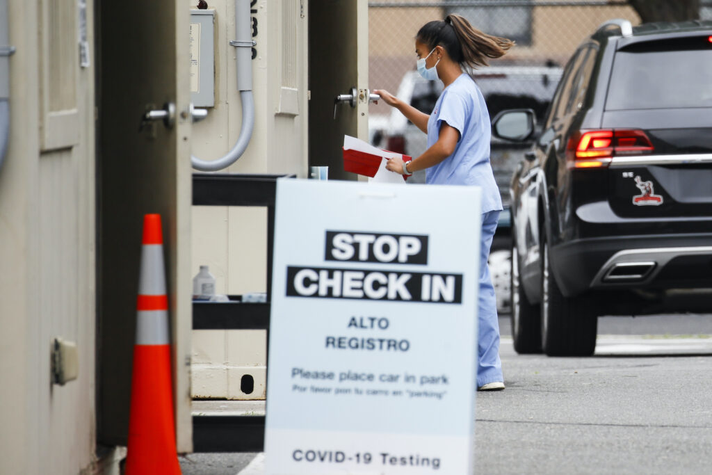 Virus Outbreak New Jersey A medical worker collects a sample after a patient self-administered a COVID-19 nasal swab test at a Walgreens pharmacy, Friday, July 31, 2020, in Newark, N.J. (AP Photo/John Minchillo)