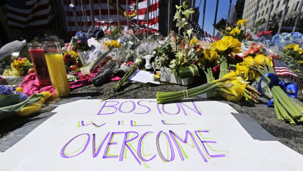 BOSTON MARATHON BOMBING In this April 17, 2013 photograph, flowers and signs adorn a barrier, two days after two explosions killed three and injured hundreds, at Boylston Street near the of finish line of the Boston Marathon at a makeshift memorial for victims and survivors of the bombing. (AP Photo/Charles Krupa)