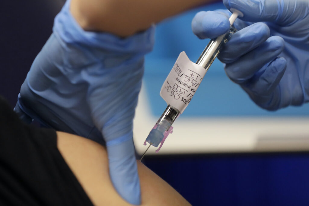 Virus Outbreak Britain Vaccine Volunteer is injected with the vaccine as part of an Imperial College vaccine trial, at a clinic in London, Wednesday, Aug. 5, 2020. Imperial College is working on the development of a COVID-19 vaccine. (AP Photo/Kirsty Wigglesworth)