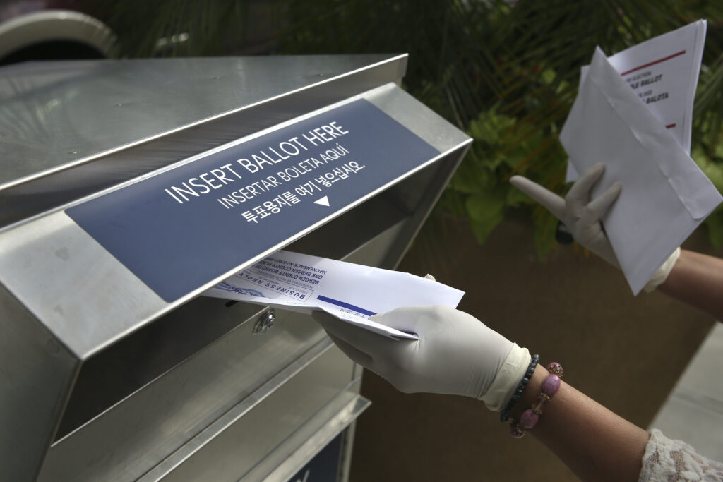 Election 2020 Voting Drop Boxes In this July 7, 2020 photo a woman drops off a mail-in ballot at a drop box in Hackensack, N.J. (AP Photo/Seth Wenig)