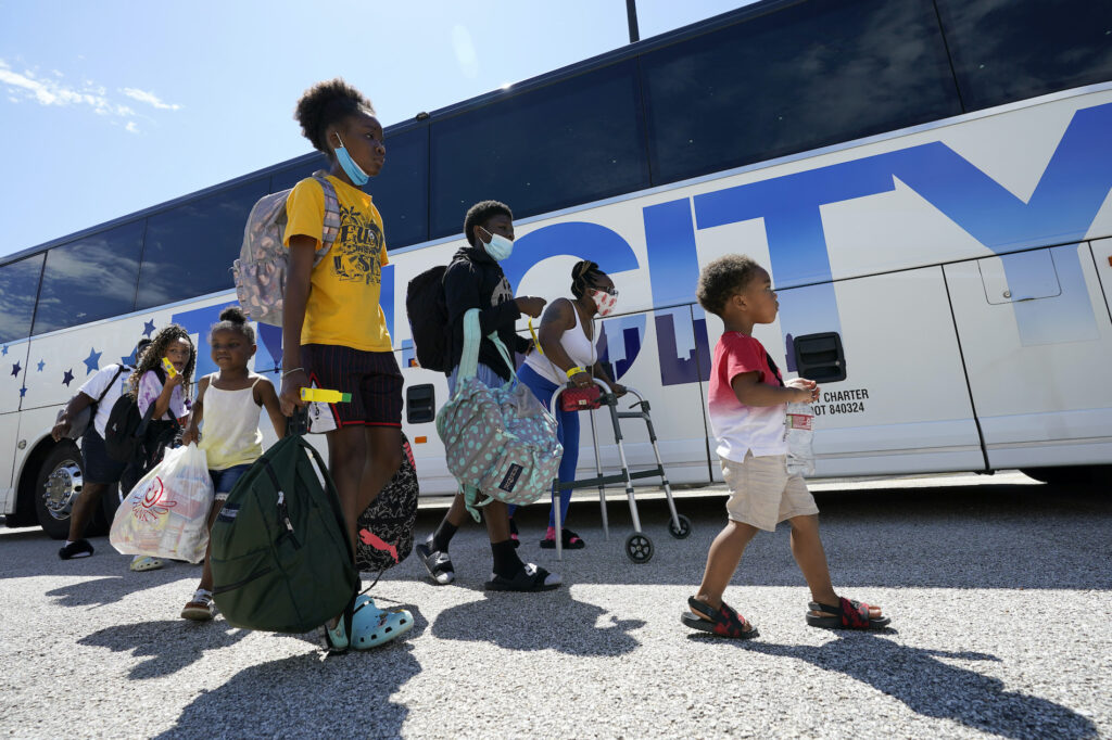 Tropical Weather Texas Evacuees walk to board buses Tuesday, Aug. 25, 2020, in Galveston, Texas. The evacuees are being taken to Austin, Texas, as Hurricane Laura heads toward the Gulf Coast. (AP Photo/David J. Phillip)