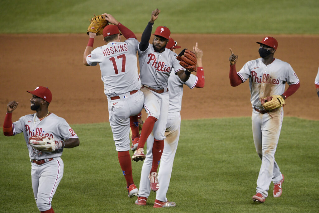 Philadelphia Phillies’ Andrew McCutchen, left, Rhys Hoskins (17), Roman Quinn, third from left, and Didi Gregorius, right, celebrate after a baseball game against the Washington Nationals, Wednesday, Aug. 26, 2020, in Washington. The Phillies won 3-2. (AP Photo/Nick Wass)