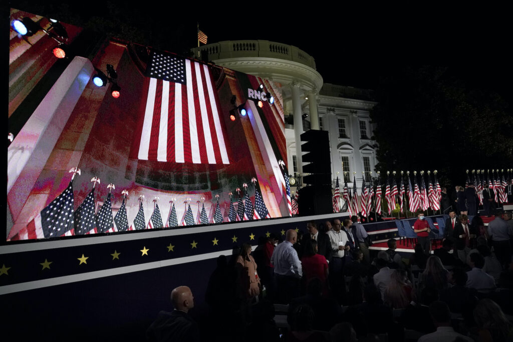 Donald Trump The Republican National Convention video is displayed on a screen as people watch from the South Lawn of the White House on the fourth day of the convention Thursday, Aug. 27, 2020, in Washington. (AP Photo/Alex Brandon)