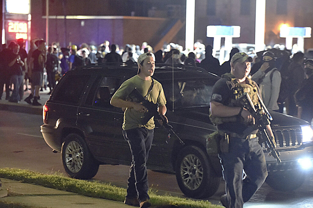 APTOPIX Police Shooting Wisconsin Kyle Rittenhouse, left, with backwards cap, walks along Sheridan Road in Kenosha, Wis., Tuesday, Aug. 25, 2020, with another armed civilian. Prosecutors on Thursday, Aug. 27, 2020 charged Rittenhouse, a 17-year-old from Illinois in the fatal shooting of two protesters and the wounding of a third in Kenosha, Wisconsin, during a night of unrest following the weekend police shooting of Jacob Blake. (Adam Rogan/The Journal Times via AP)
