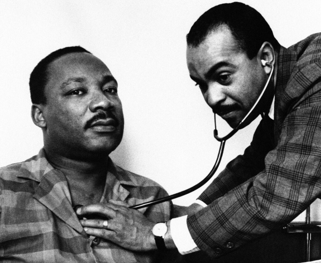 MLK Dr. Walter Lomax, a Philadelphia physician, tending to Dr. Martin Luther King, Jr. in his hotel room bed in Philadelphia, Feb. 10, 1968. (AP Photo)