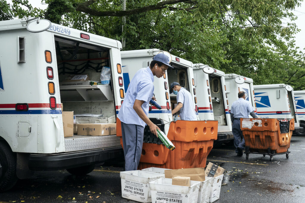 AP_USPS_postal_servcice_vote-by-mail_082020 Letter carriers load mail trucks for deliveries at a U.S. Postal Service facility