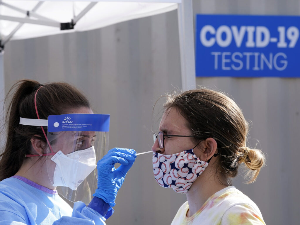 A woman is tested for COVID-19 at a walk-up testing site