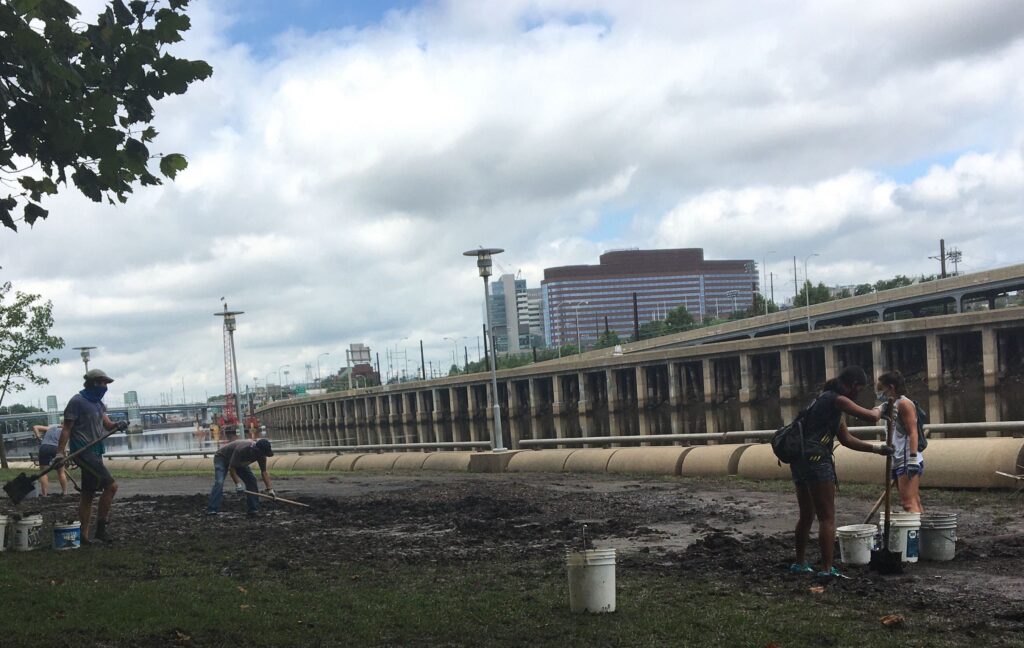 Image from iOS (120) Volunteers helped clean up a mess of debris and mud left on the Schuylkill Bank post-Tropical Storm Isaias. (Katie Meyer/WHYY)
