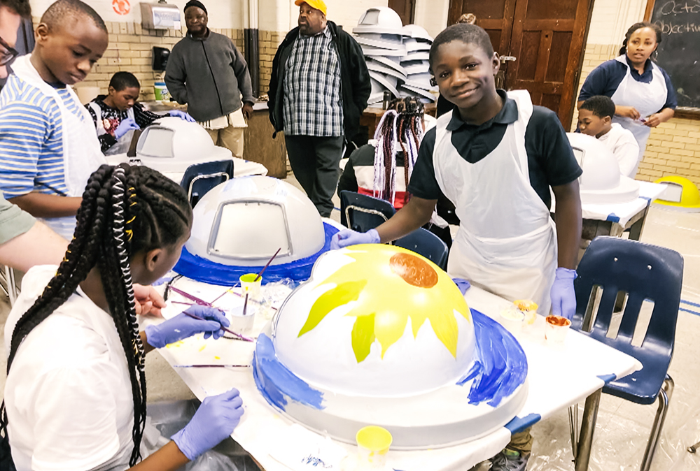Southwest Philly community members painting public trash cans to help clean up their neighborhoods