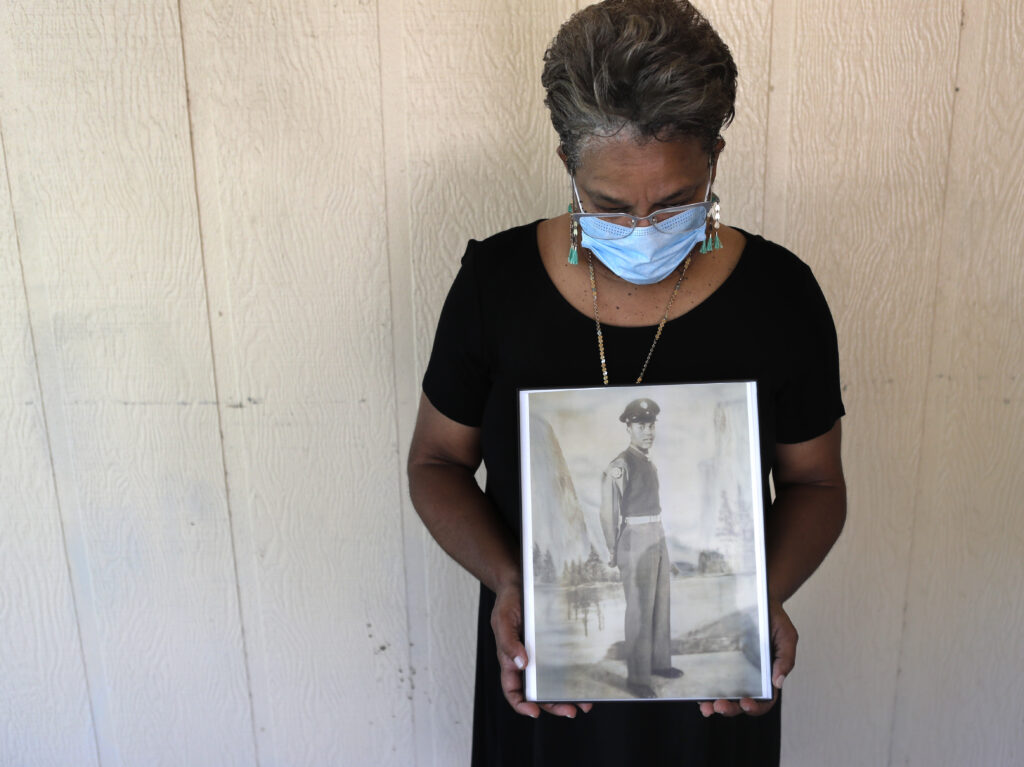 Belvin Jefferson White poses with a portrait of her father Saymon Jefferson, who died from COVID-19, in Baton Rouge, La., in May. (Gerald Herbert/AP)
