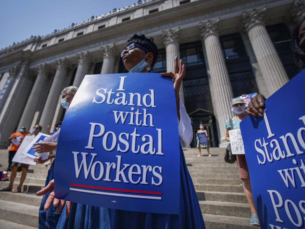 Retired postal worker Glenda Morris protests postal cutbacks on Aug. 25, 2020, in New York. African Americans make up 27 percent of the Postal Service, about twice their share of the overall workforce. (Mark Lennihan/AP)