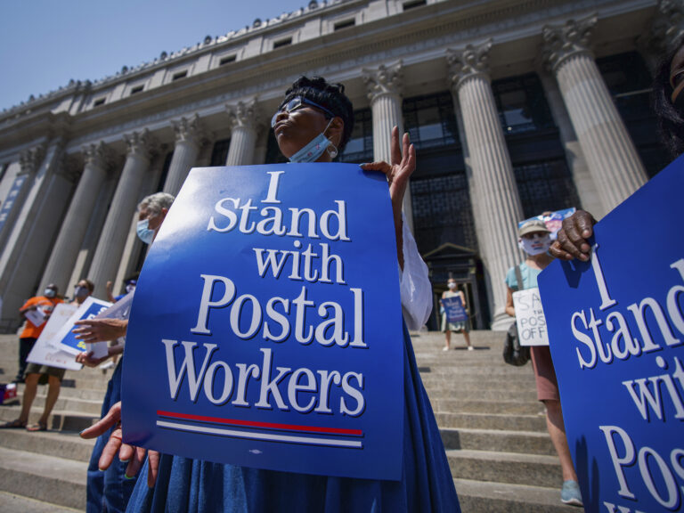 Retired postal worker Glenda Morris protests postal cutbacks on Aug. 25, 2020, in New York. African Americans make up 27 percent of the Postal Service, about twice their share of the overall workforce. (Mark Lennihan/AP)