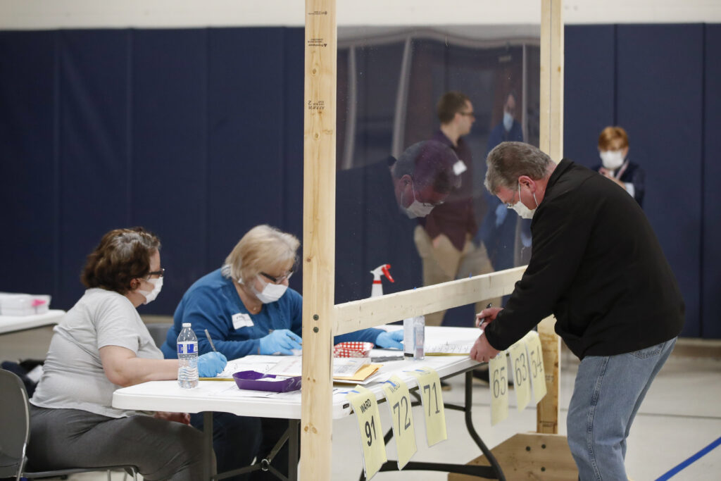 A man checks to cast his ballot in Kenosha, Wis., on April 7. A new study suggests that in-person voting in that Wisconsin primary did not produce a surge of new coronavirus cases. A man checks to cast his ballot in Kenosha, Wis., on April 7. A new study suggests that in-person voting in that Wisconsin primary did not produce a surge of new coronavirus cases. (Kamil Krzaczynski /AFP via Getty Images)