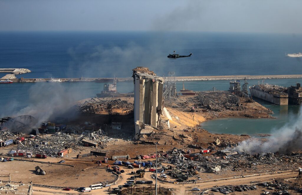 A helicopter hovers over damaged grain silos in Beirut’s port on Wednesday, one day after a powerful explosion tore through Lebanon’s capital. A helicopter hovers over damaged grain silos in Beirut's port on Wednesday, one day after a powerful explosion tore through Lebanon's capital.