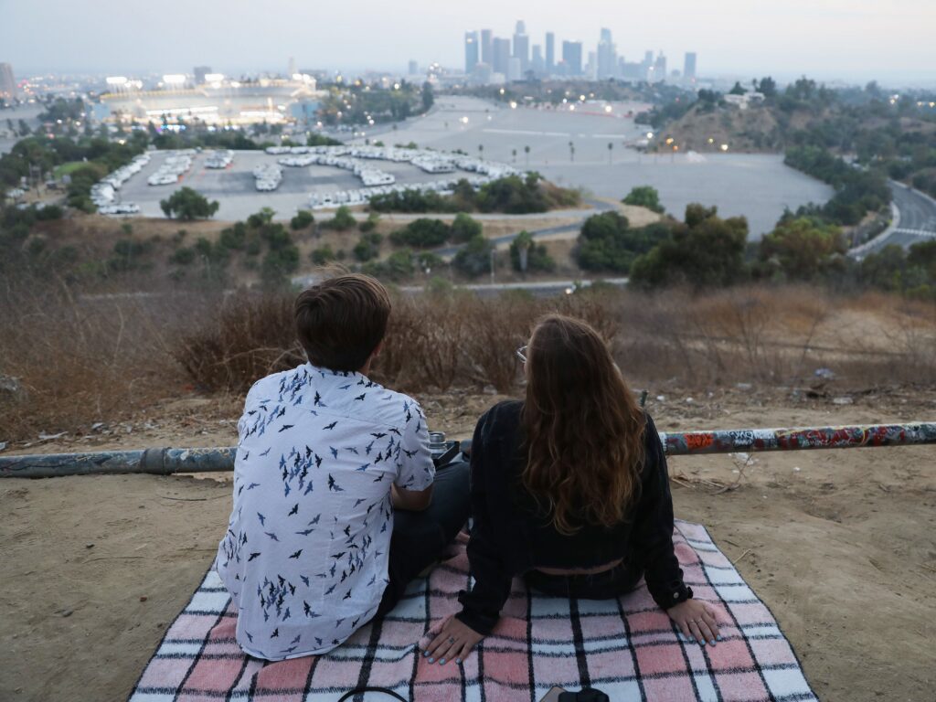 People gather for a picnic on a hillside overlooking Dodger Stadium in Los Angeles during a game Saturday. Spectators are currently not allowed to attend Major League Baseball games in order to prevent the spread of the coronavirus. People gather for a picnic on a hillside overlooking Dodger Stadium in Los Angeles during a game Saturday. Spectators are currently not allowed to attend Major League Baseball games in order to prevent the spread of the coronavirus.