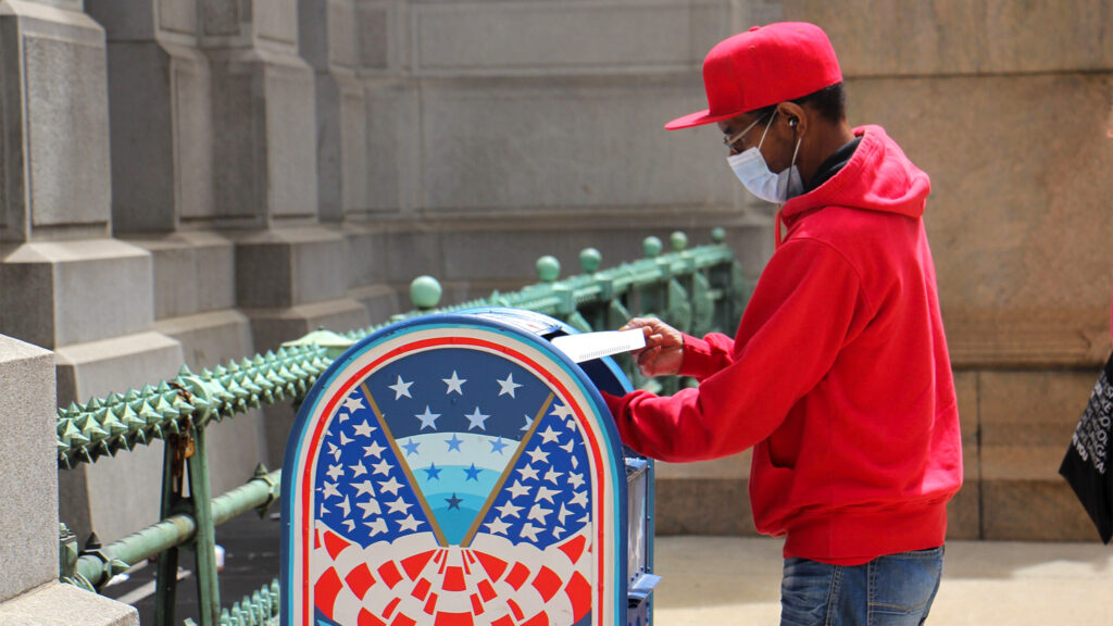 mailinballotdropbox-kimpaynter-crop A voter places his mail-in ballot in a box outside City Hall.