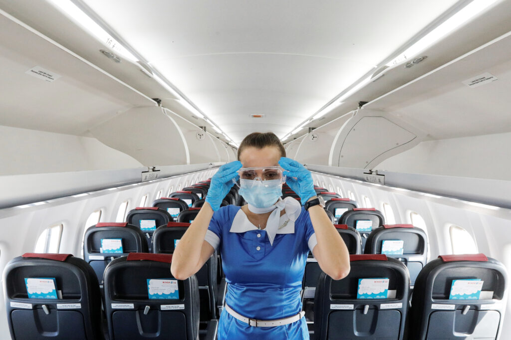 A flight attendant adjusts protective glasses. There has been little documentation about COVID-19 transmission on planes. A flight attendant adjusts protective glasses. There has been little documentation about COVID-19 transmission on planes.