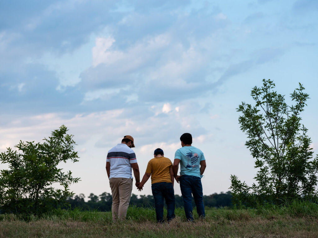 Honduran migrants, Ricardo Sr., (left), his son Ricardo Jr., 13, and his cousin Jorge, 16, walk near their home in Texas. When the two teenage boys crossed the border illegally into Texas last month, they turned themselves into Border Patrol. They were later escorted to a hotel by armed men in civilian clothes. Honduran migrants, Ricardo Sr., (left), his son Ricardo Jr., 13, and his cousin Jorge, 16, walk near their home in Texas. When the two teenage boys crossed the border illegally into Texas last month, they turned themselves into Border Patrol. They were later escorted to a hotel by armed men in civilian clothes. (Scott Dalton for NPR)