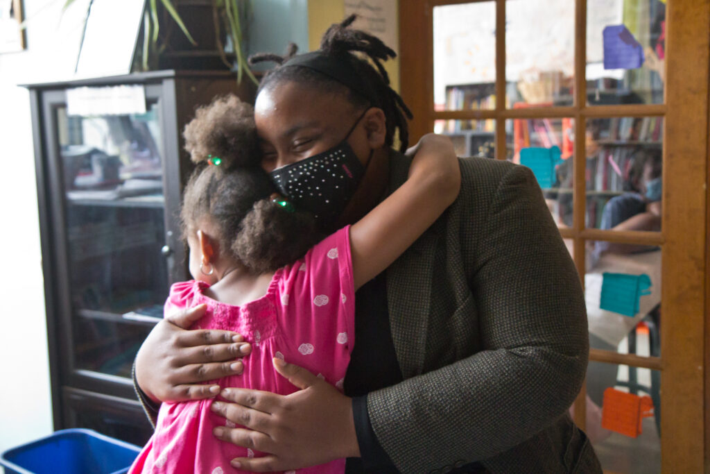 2020 9 18 k paynter pandemic school pods-4 Tree House Books program director Sabriaya Shipley hugs Ayah Robinson, 8. (Kimberly Paynter/WHYY)