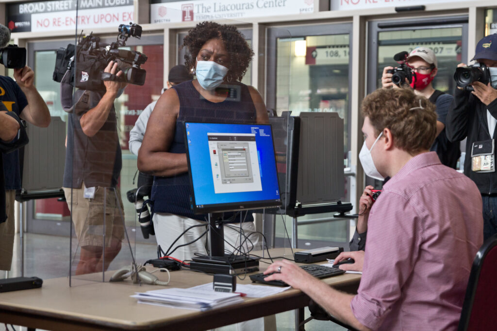 2020 9 29 k paynter satellite election offices-4 The first voter at the Liacouras Center satellite election office, Priscilla Bennett, first requests a ballot, which will be printed at the office. (Kimberly Paynter/WHYY)