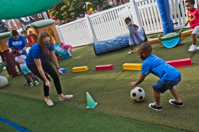 Rinn Erin, manager of Today’s Child Learning Centers, plays with kids at day care