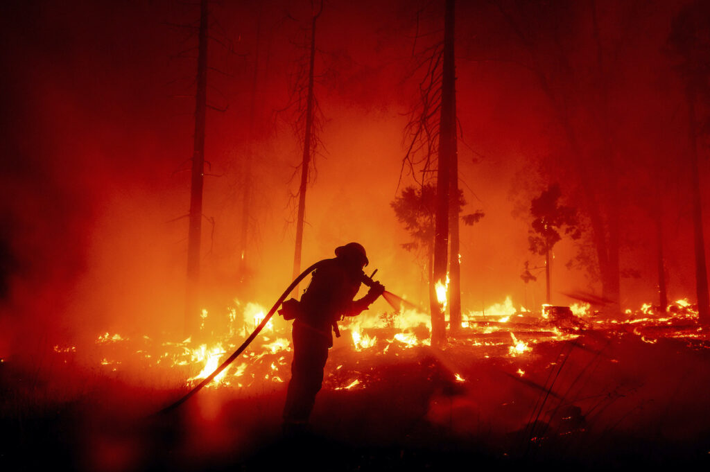 Western Wildfires-Exhausted Resources FILE - In this Sept. 7, 2020, file photo, a firefighter battles the Creek Fire as it threatens homes in the Cascadel Woods neighborhood of Madera County, Calif. (AP Photo/Noah Berger,File)