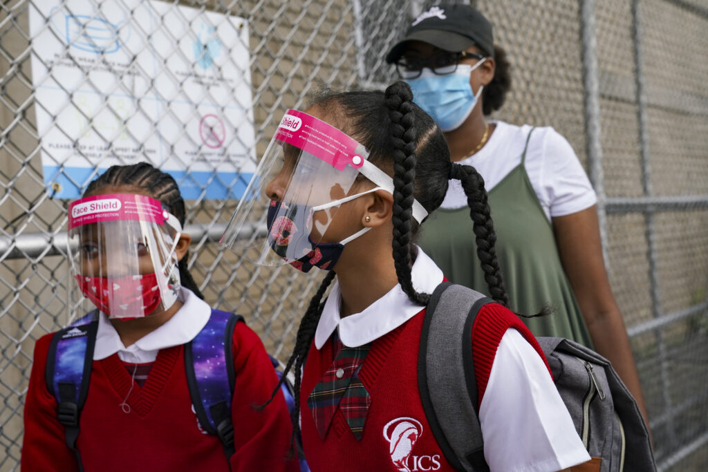 Virus Outbreak NYC Schools In this Sept. 9, 2020 photo, students wear protective masks as they arrive for classes at the Immaculate Conception School while observing COVID-19 prevention protocols in The Bronx borough of New York. (AP Photo/John Minchillo)