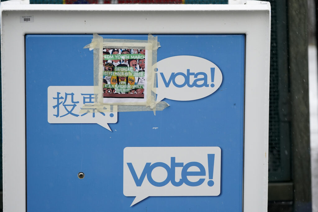 A poster for a youth march is pasted to the side of a King County ballot drop box, closed until ballots are mailed about three weeks before the election, on a Seattle street Thursday, Sept. 24, 2020. (AP Photo/Elaine Thompson)