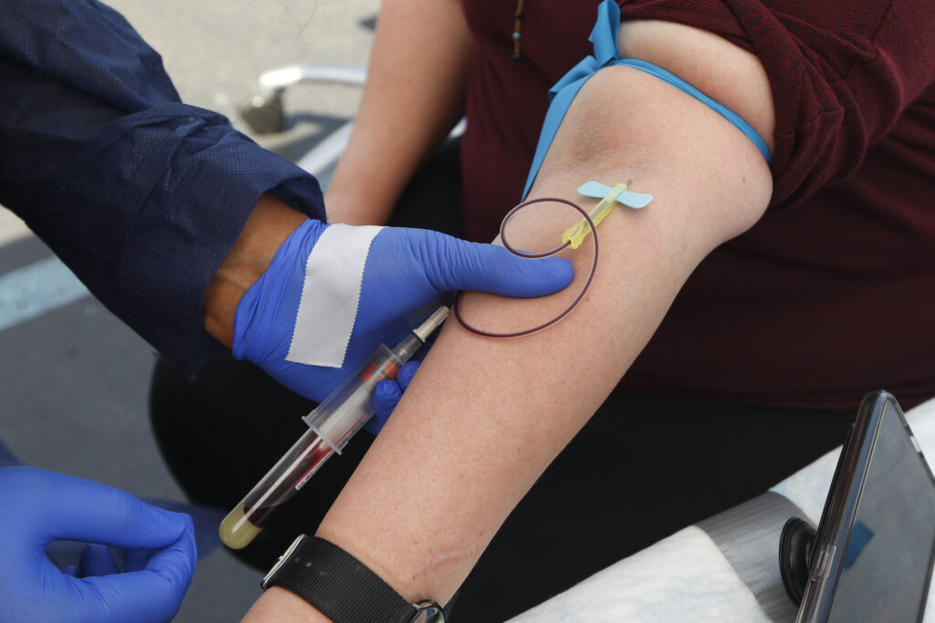 In this Friday, June 12, 2020 file photo, a woman has blood drawn for COVID-19 antibody testing in Dearborn, Mich. (AP Photo/Paul Sancya)