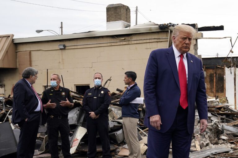President Donald Trump turns around after talking with law enforcement officials Tuesday, Sept. 1, 2020, as he tours an area damaged during demonstrations after a police officer shot Jacob Blake in Kenosha, Wis. At left, Attorney General William Barr and acting Homeland Security Secretary Chad Wolf talk with police officers. (AP Photo/Evan Vucci)