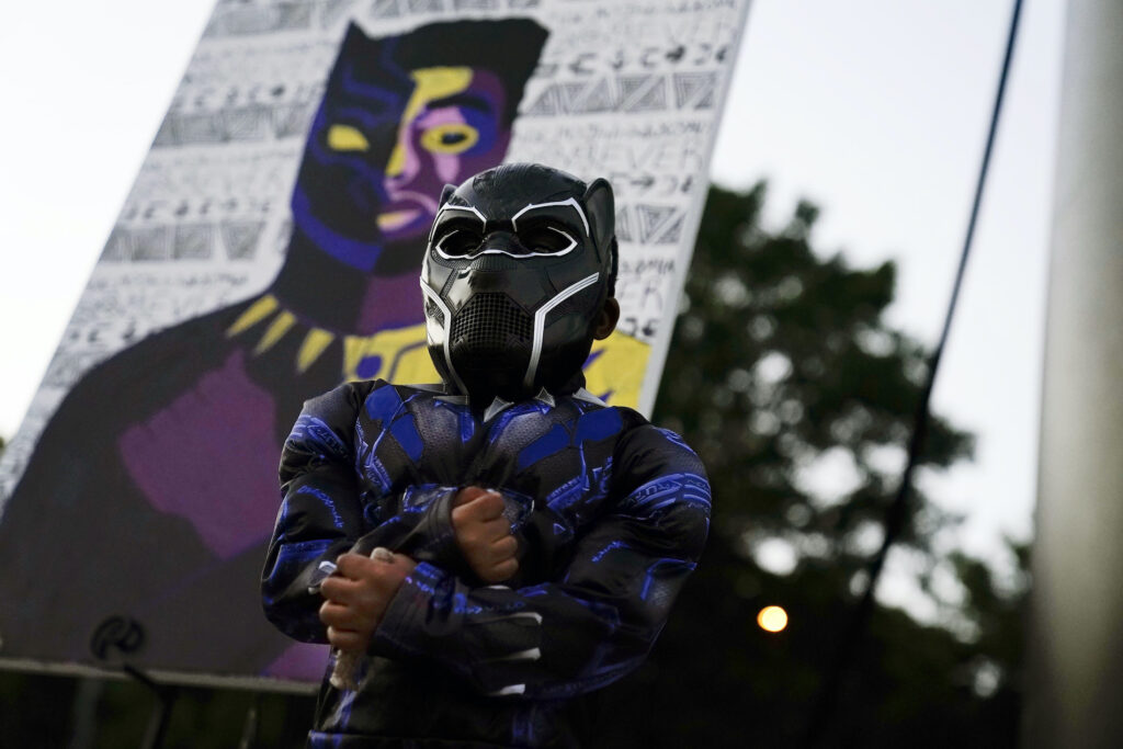APTOPIX Chadwick Boseman Tribute Mason Wilkes, 4, of South Carolina, poses for his father in a Black Panther costume, in front of a paining during a Chadwick Boseman Tribute on Thursday, Sept. 3, 2020, in Anderson, S.C. (AP Photo/Brynn Anderson)