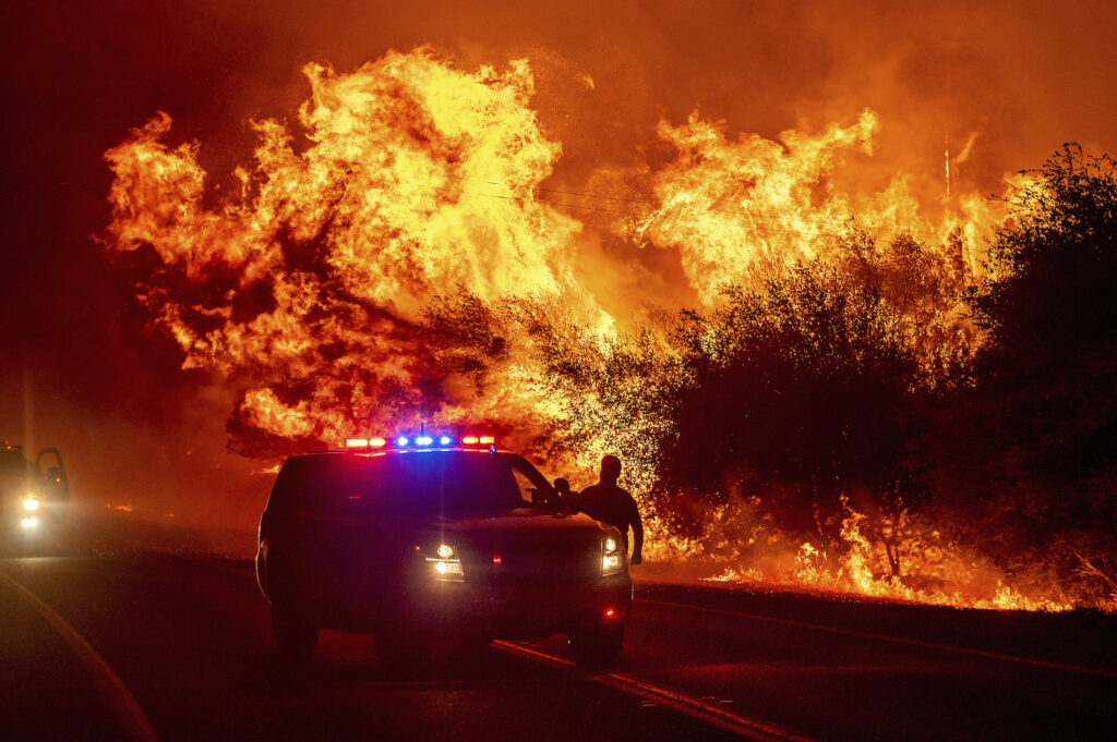 APTOPIX California Wildfires Flames lick above vehicles on Highway 162 as the Bear Fire burns in Oroville, Calif.