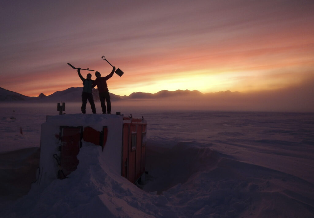 Antarctica Keeping COVID-Free In this handout photo provided by British Antarctic Survey, field guides Sarah Crowsley, left, and Sam Hunt, right, pose for a photo after digging out the caboose, a container used for accommodation that can be moved by a tractor, at Adelaide island, in Antarctica on Friday, June 19, 2020. (Robert Taylor/British Antarctic Survey via AP)