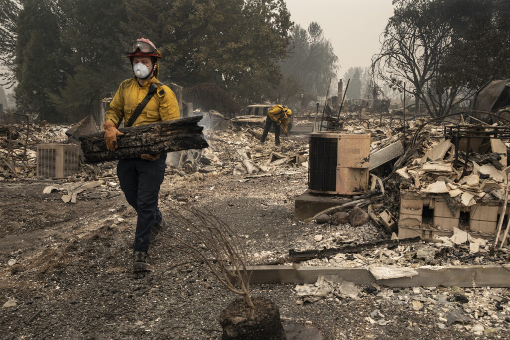 Pacific Northwest Wildfires Jackson County District 5 firefighter Captain Aaron Bustard works on a smoldering fire in a burned neighborhood in Talent, Ore., Friday, Sept. 11, 2020, as destructive wildfires devastate the region. (AP Photo/Paula Bronstein)