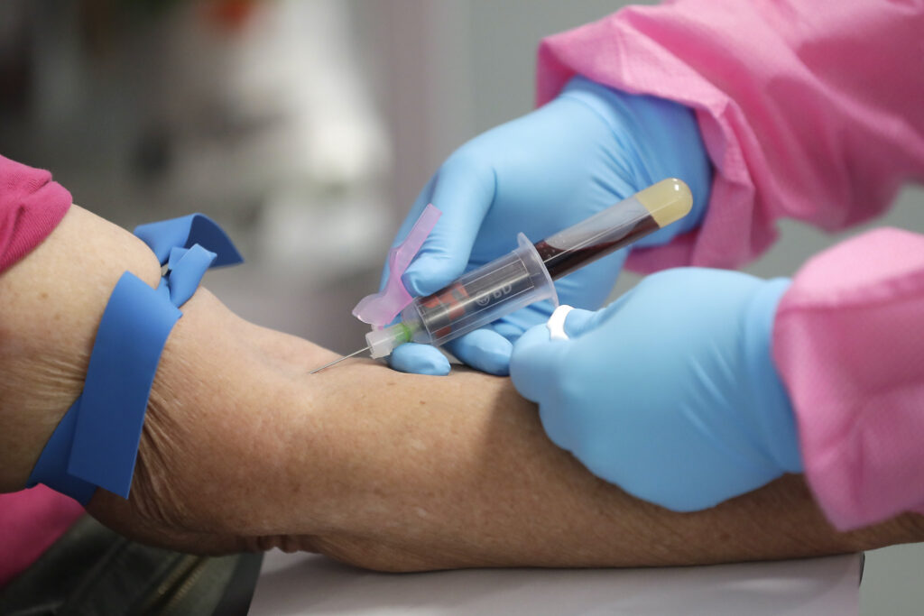 A health worker draws blood from a patient A health worker draws blood from a patient