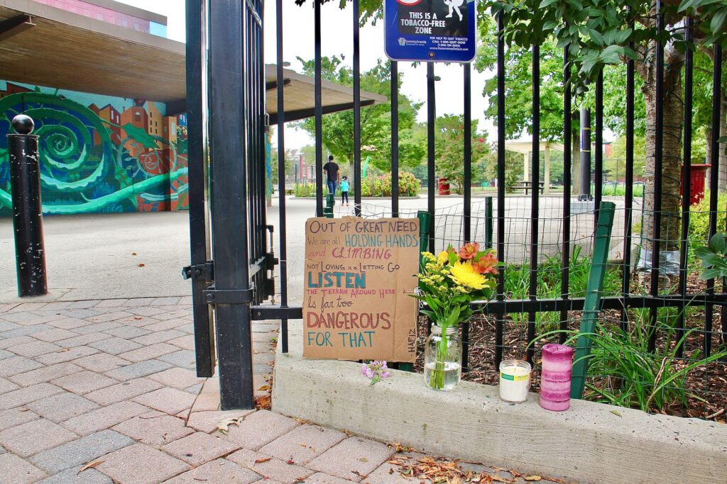 Image from iOS (147) A memorial to five people shot on a basketball court, two fatally, stands at the entrance to Roberto Clemente Playground. (Emma Lee/WHYY)