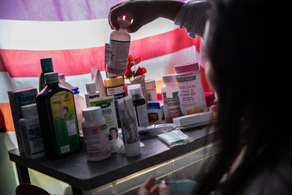 Sick Immigrants Isolate At Home During Recovery From Suspected COVID-19 Cases A woman recovering from fever linked to COVID-19 checks medications in her home