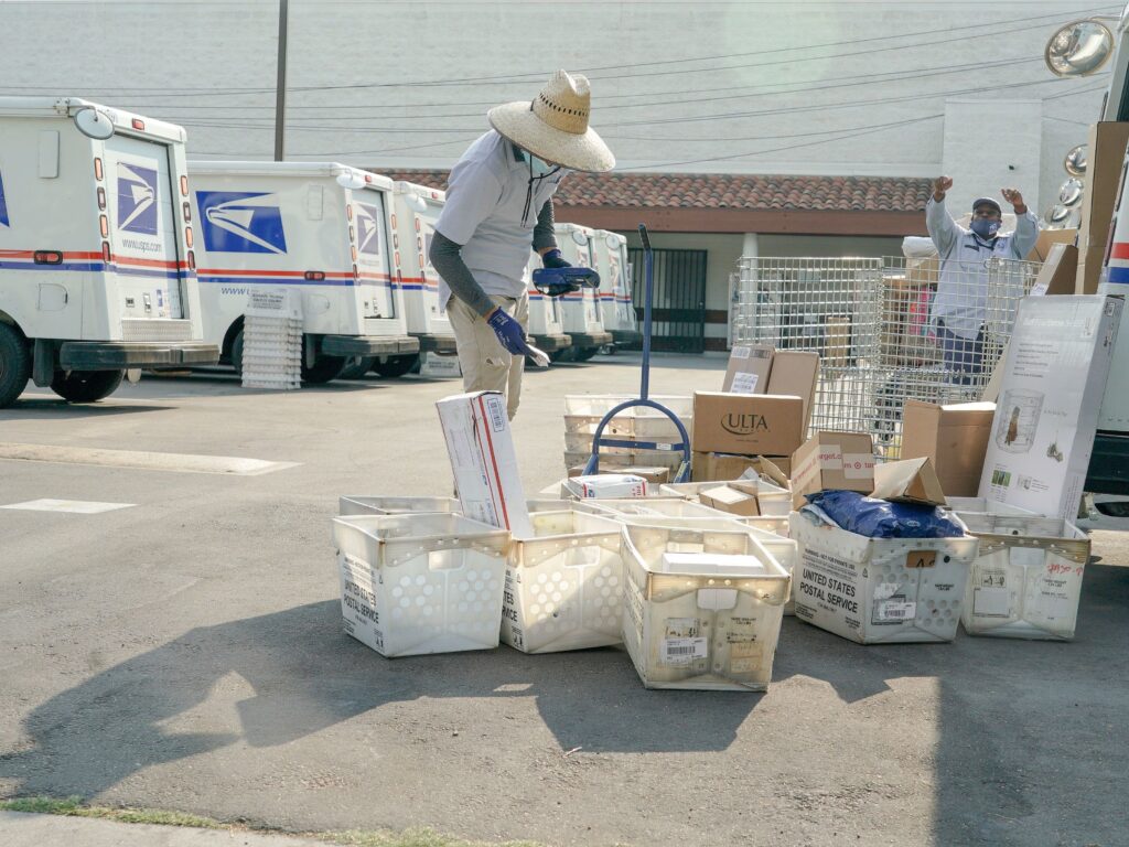 Postal workers sort, load and deliver mail at a United States Postal Service location in Los Angeles, Calif. (KYLE GRILLOT/AFP via Getty Images)