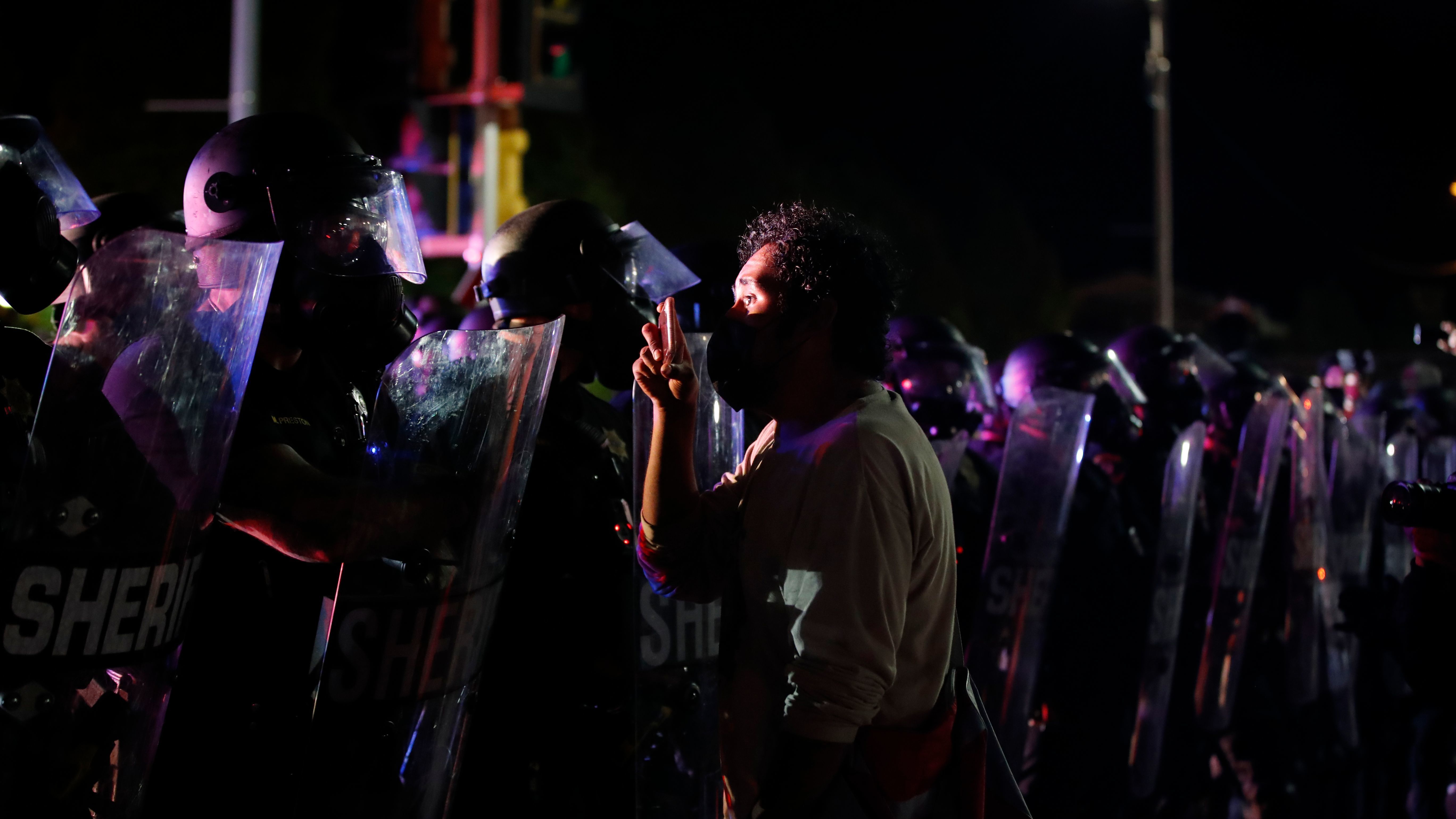 A protester stands face to face with police during demonstrations against the shooting of Jacob Blake in Kenosha, Wis., on August 25, 2020.