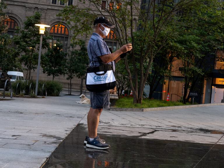 A Census Bureau worker wearing a face covering stands in a park in New York City in August. The bureau confirmed on Tuesday that door knocking is ending in some areas earlier than Sept. 30. (Alexi Rosenfeld/Getty Images)
