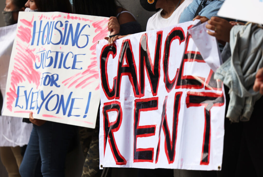 Demonstrators hold up signs as they gather at Brooklyn Housing court during a 'No Evictions, No Police' national day of action