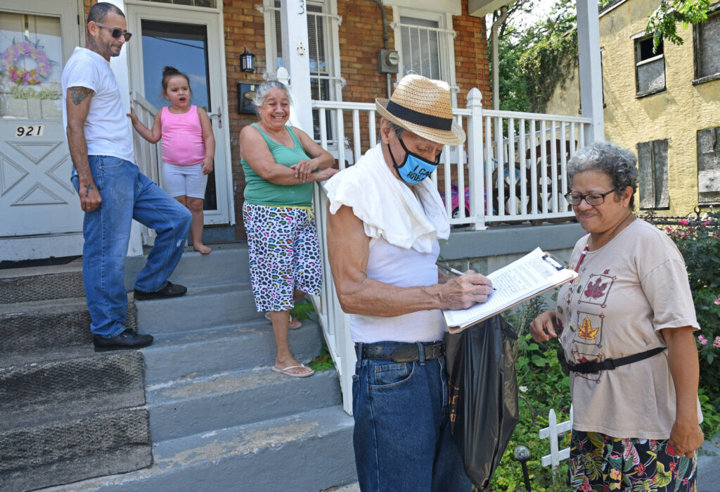 petition1 In East Camden, Nelson Berrios signs the petition for nonpartisan elections for Mary Cortes, right on Aug. 22. (April Saul for WHYY)