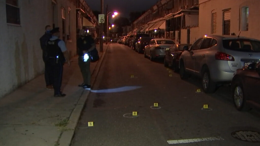 west-philadelphia-4-shot-09272020 (1) Philadelphia Police Department investigators stand on a sidewalk as bullet casings and evidence markers lay on the ground after a shooting
