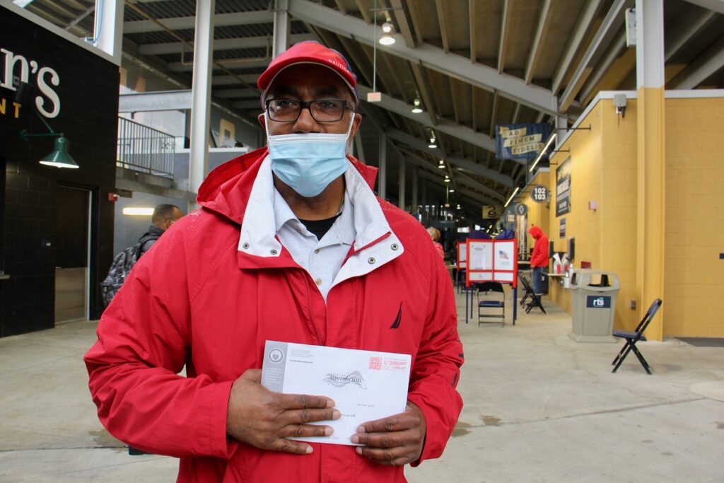 Darryl Turner of Chester, Pa., stops at the pop-up voter service center at Subaru Park to drop off his mail-in ballot. (Emma Lee/WHYY)