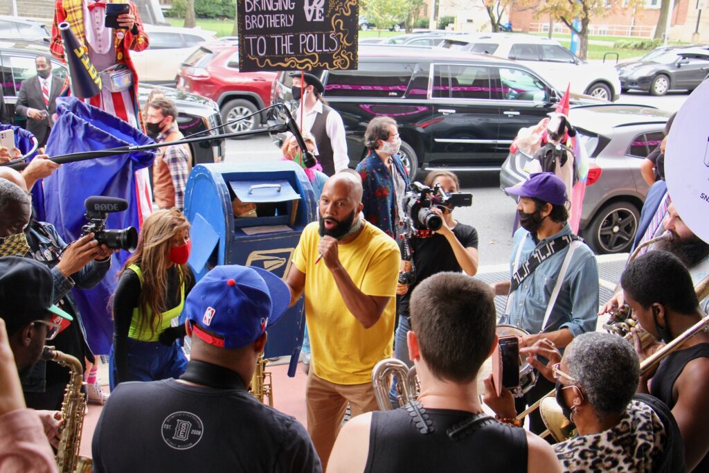 2020 10 23-e lee-common the rapper-philadelphia liacouras center-cirque d’vote Common jams with the Snacktime Band outside the Liacouras Center, a surprise addition to the Cirque d'Vote entertainment for voters waiting in line there. (Emma Lee/WHYY)
