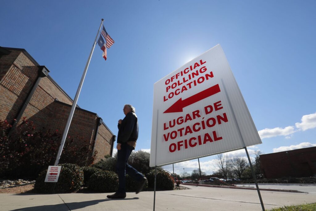 AP20261611489059-1920×1280 In this Feb. 26, 2020 file photo, using both the English and Spanish language, a sign points potential voters to an official polling location during early voting in Dallas. (LM Otero/AP Photo)